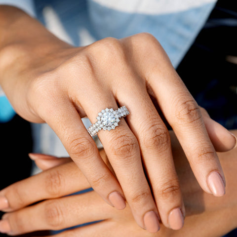 Close-up of a hand wearing a diamond ring with a blurred background